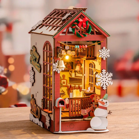 Decorative wooden house with lights and snowman on a blurred background