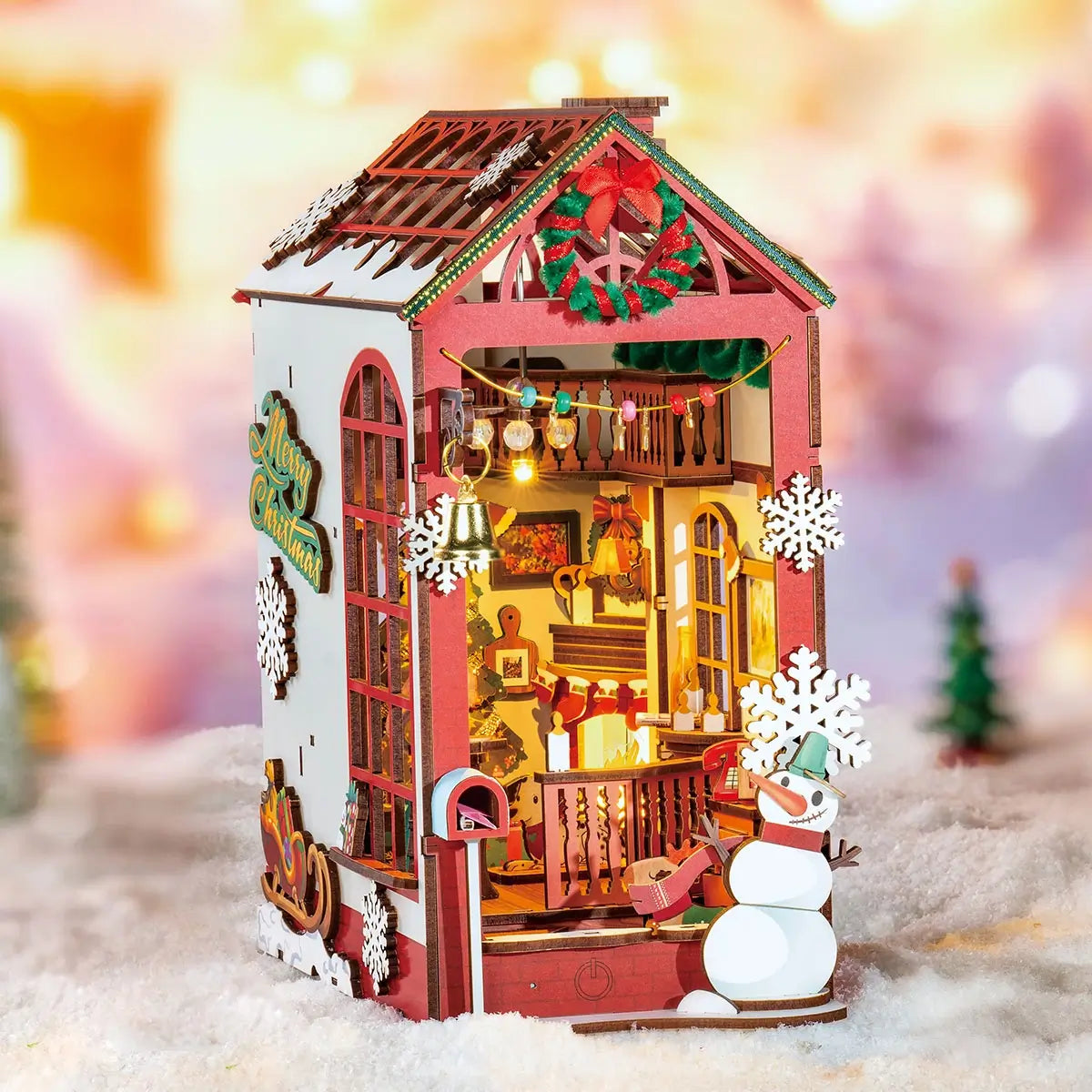 Decorative Christmas house with lights and snowman in a snowy scene