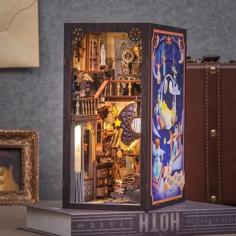 A completed miniature diorama featuring a magical or whimsical theme, with intricate details and a protective dust cover visible.