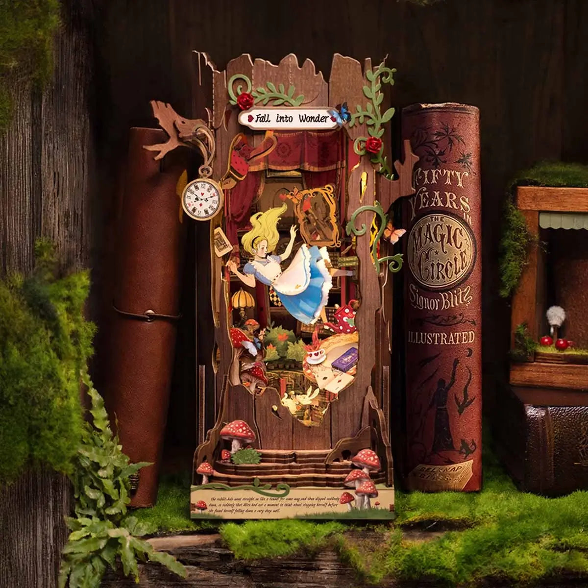 Alice in Wonderland book nook kit with LED lights turned on, glowing warmly inside the miniature scene.