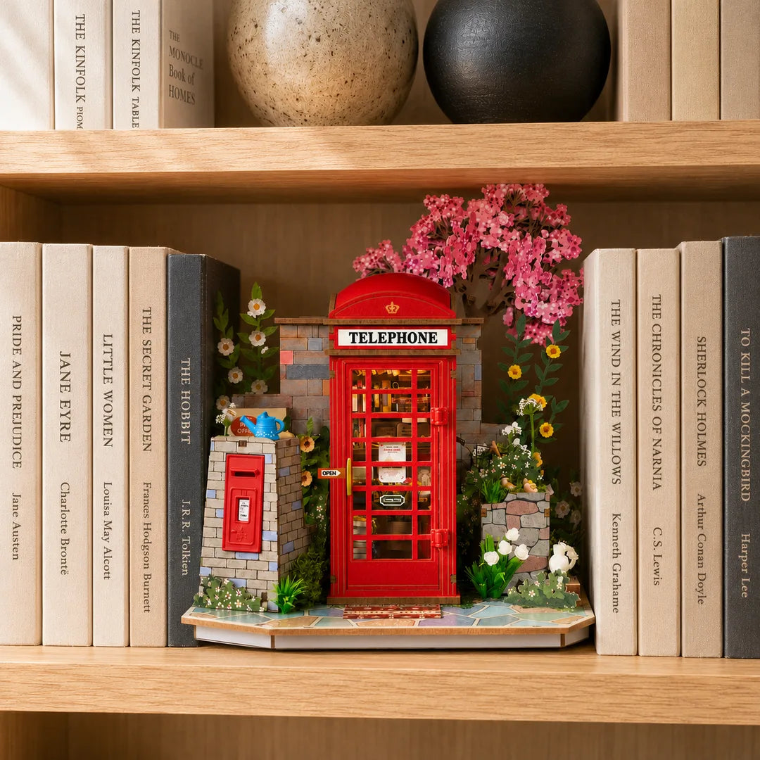 Blossom Corner DIY Book Nook displayed between classic English books on a wooden bookshelf