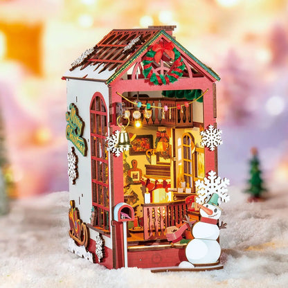 Decorative Christmas house with lights and snowman in a snowy scene