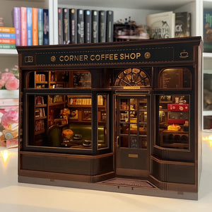 Model of a corner coffee shop with detailed interior and 'Corner Coffee Shop' sign.